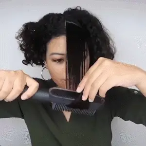 Mulher utilizando a escova alisadora